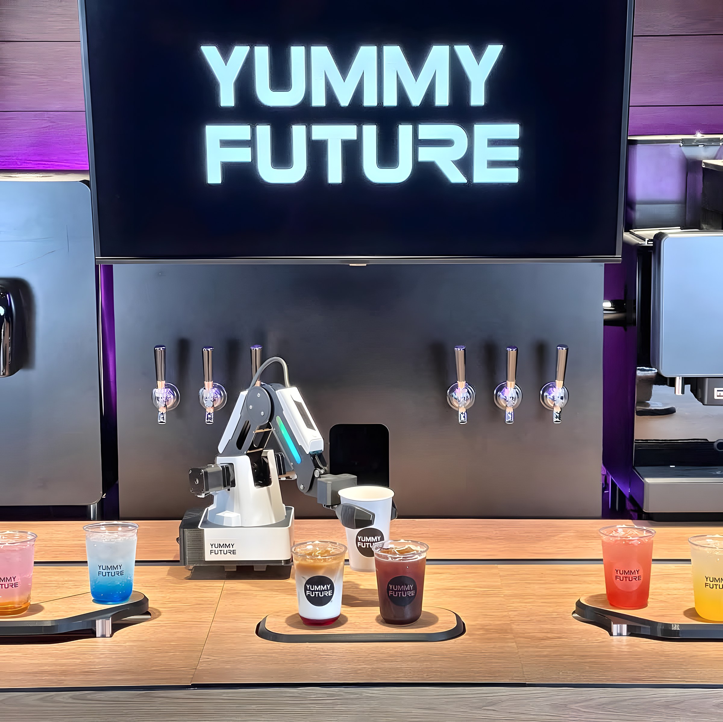 Yummy Future robotic arm pouring a drink behind the counter